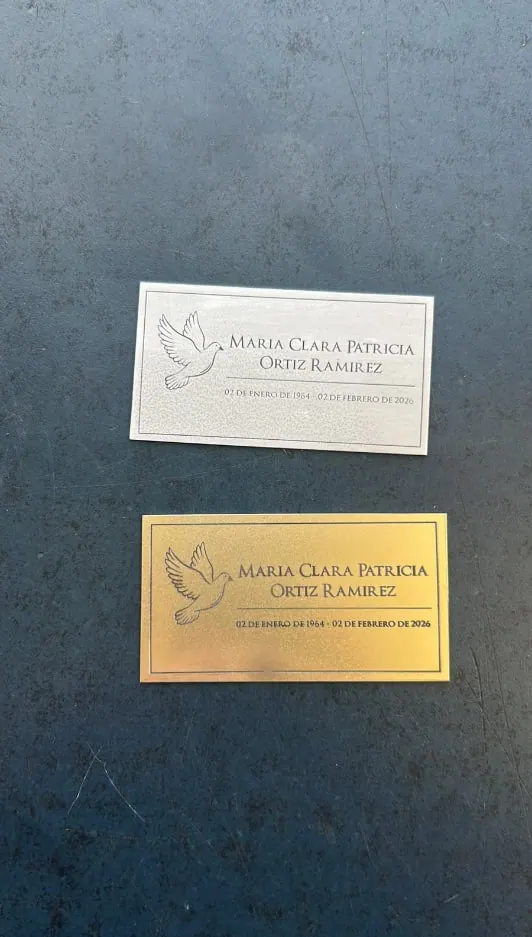 Placas de aluminio plateada y dorada con un nombre grabado