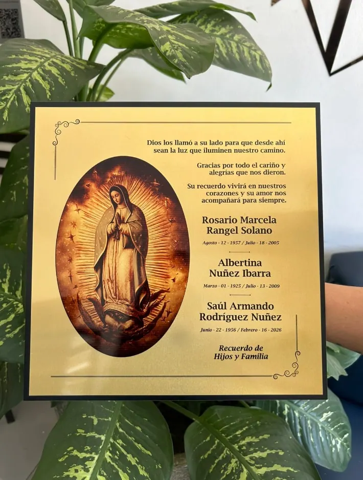 Placa dorada con imagen religiosa y nombres grabados