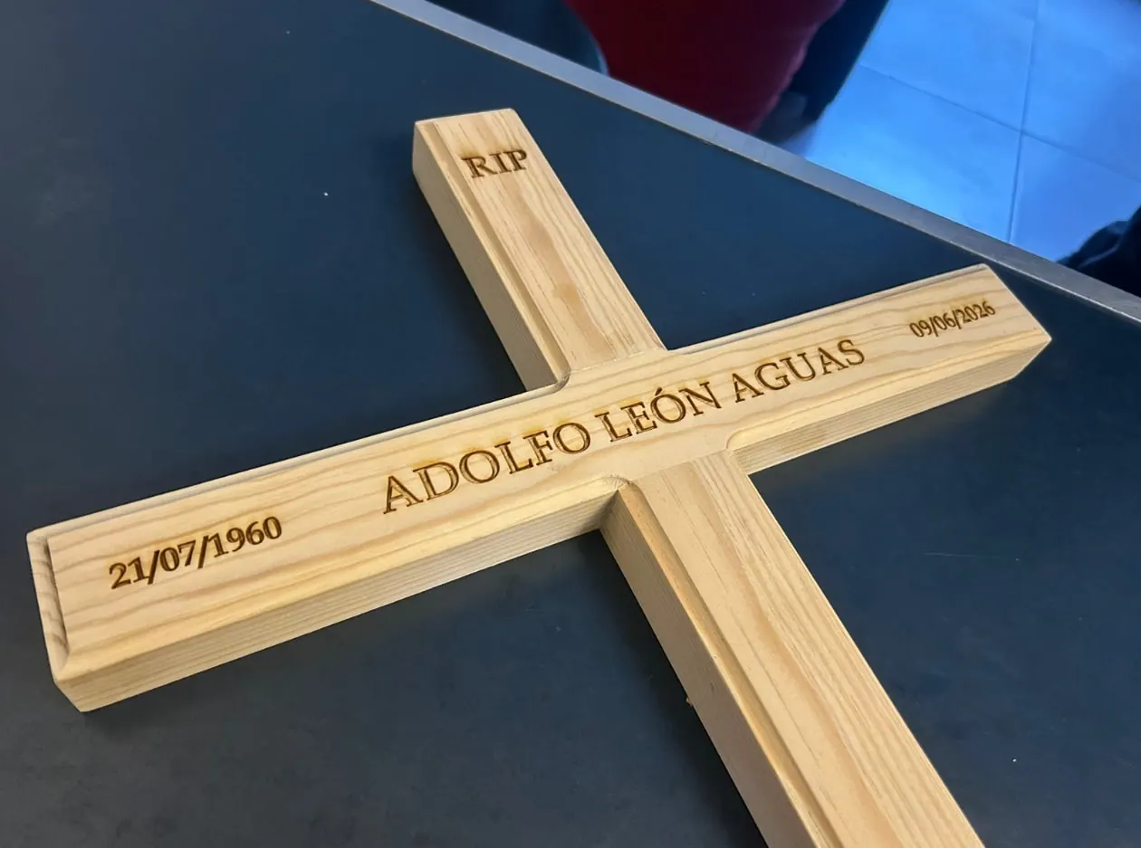 Cruz de madera con nombre y fechas grabados